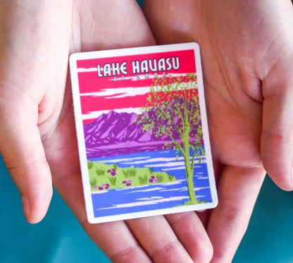 Sticker of Lake Havasu with a scenic design held between two hands against a teal background