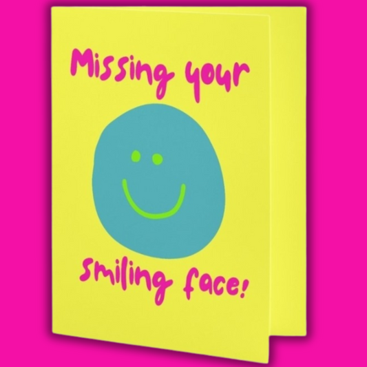 Card with a smiley face and text 'Missing your smiling face!' on a pink background