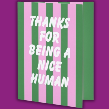 Notebook with green and pink striped cover and 'Thanks for being a nice human' text on a purple background